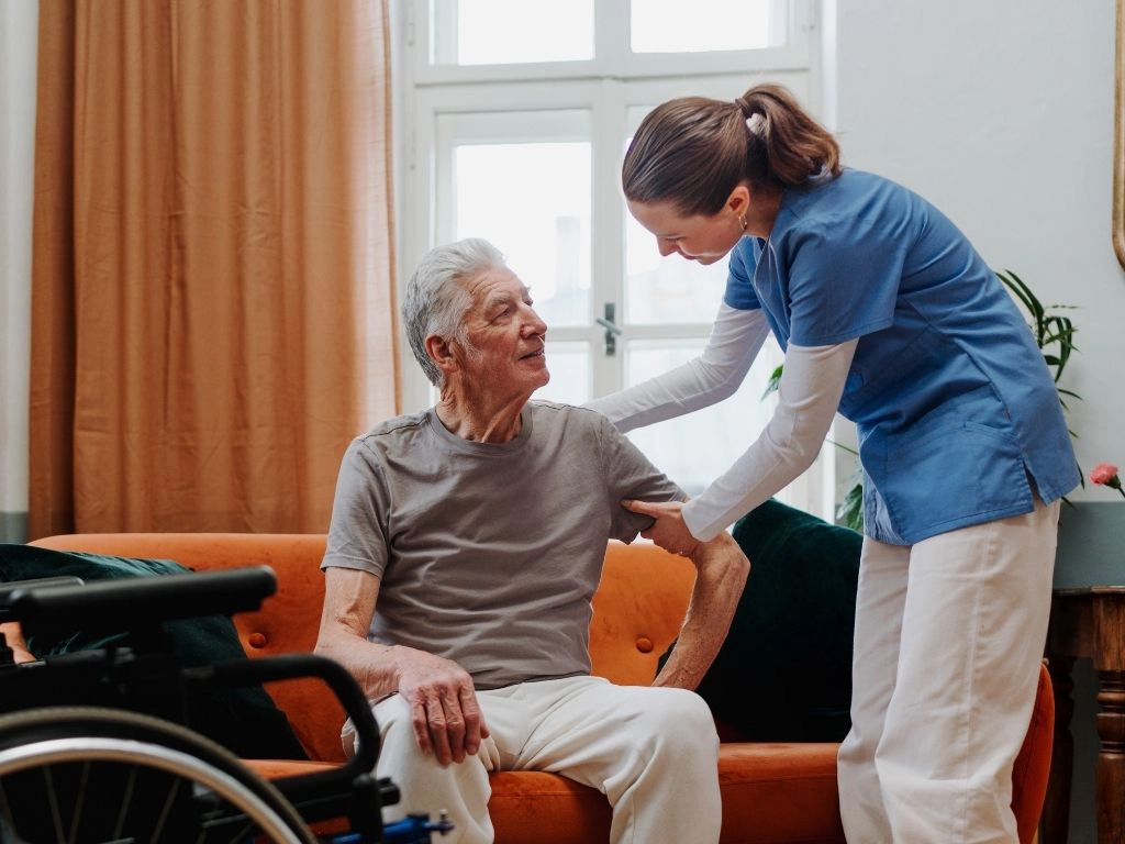 Caregiver helping a senior to stand Our aged and disabled waiver services lets seniors benefit from the care of a compassionate caregiver