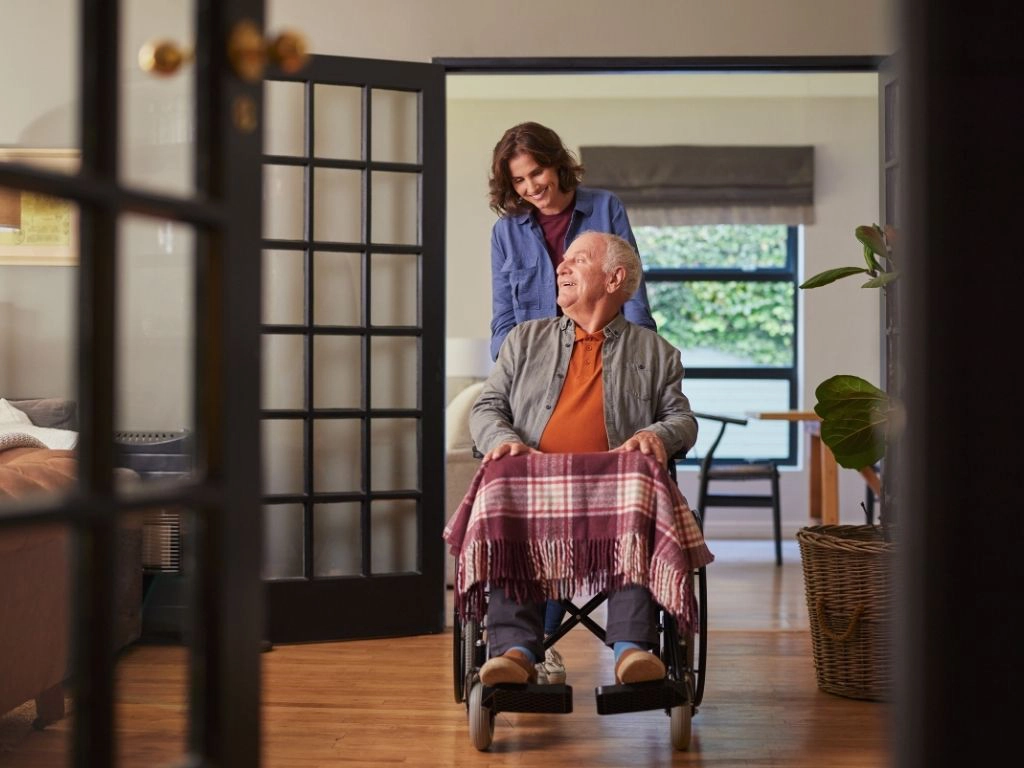 Caregiver helping senior in a wheelchair Caregiver available to help with 24-hour care